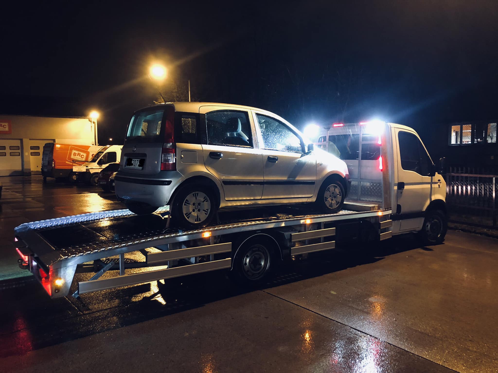 Holowanie samochodu osobowego nocą na lawecie